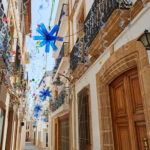 Calle del casco histórico de Jávea decorada con banderines
